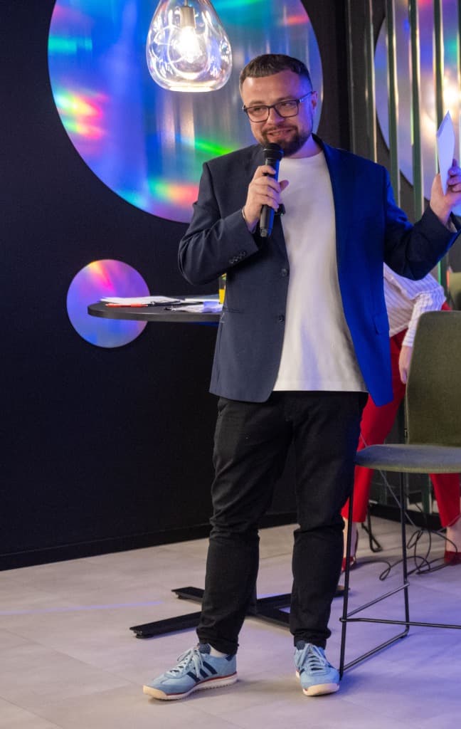 Wojtek Blazalek speaking on stage